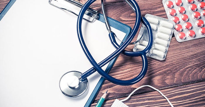 A blue stethoscope sits on a clip board.